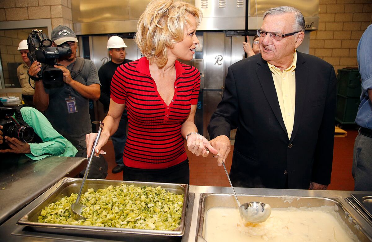 La actriz Pamela Anderson habla con el jefe de policía Joe Arpaio mientras se preparan para servir la primera comida totalmente vegetariana a los presos de la Cárcel del Condado de Maricopa. (AP)