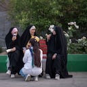 Una joven iraní sin el hiyab obligatorio se sienta junto a sus amigas con velo mientras visita la Feria Internacional del Libro en la gran mezquita Imam Jomeini en el centro de Teherán