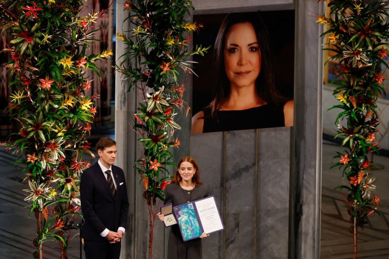 Ana Corina Sosa (R), hija de la líder de la oposición venezolana María Corina Machado, recibe el Premio Nobel de la Paz para su madre de manos del presidente del Comité Nobel Noruego, Jorgen Watne Frydnes (L), en la ceremonia del Premio Nobel de la Paz en el Ayuntamiento de Oslo el 10 de diciembre de 2025 en Oslo, Noruega. El Premio Nobel de la Paz 2025 fue otorgado a Machado por sus esfuerzos por llevar la democracia a Venezuela, desafiando el gobierno de mano dura del presidente venezolano Nicolás Maduro, quien ha sido presidente desde 2013. (Foto de Odd ANDERSEN / AFP)