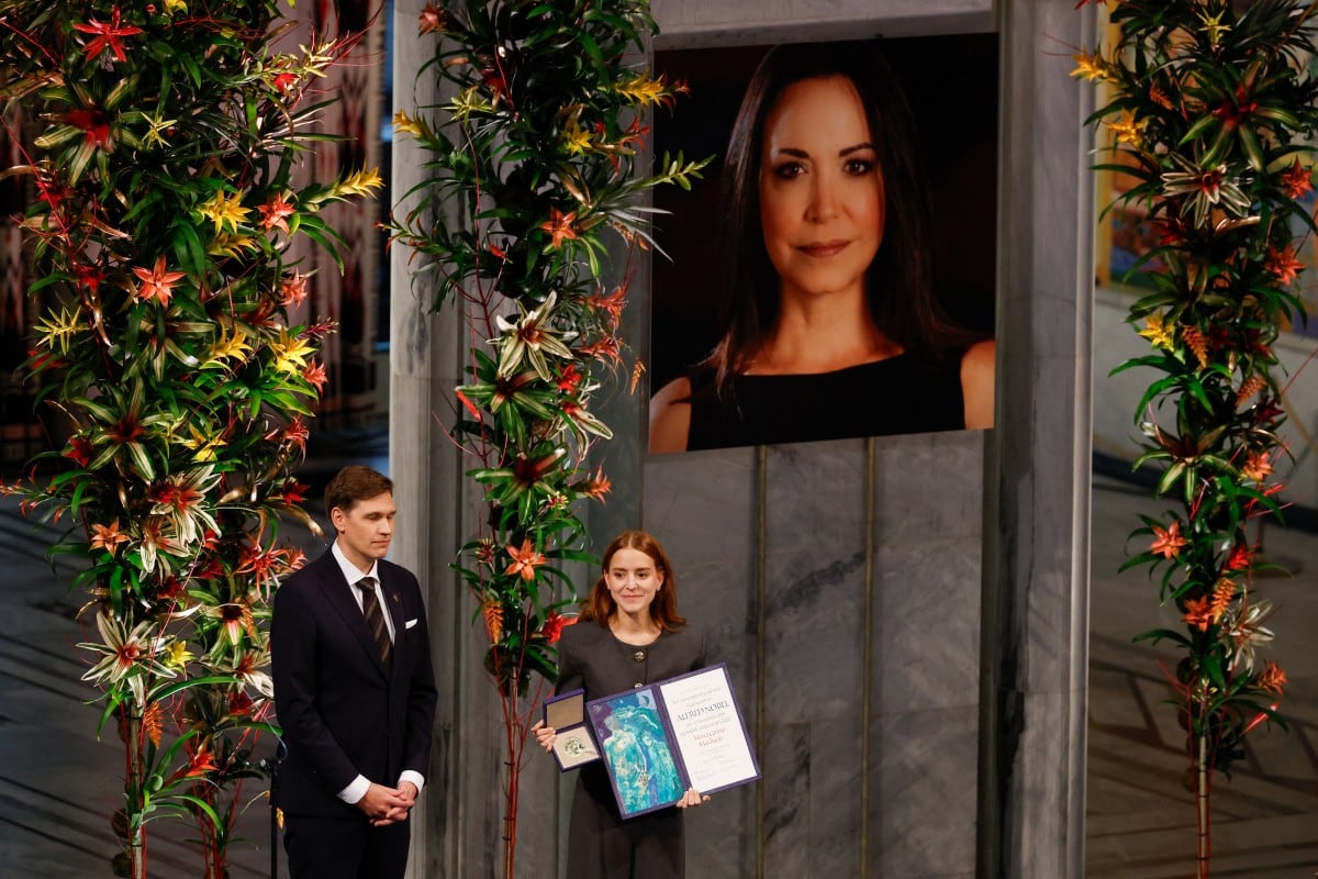 Ana Corina Sosa (R), hija de la líder de la oposición venezolana María Corina Machado, recibe el Premio Nobel de la Paz para su madre de manos del presidente del Comité Nobel Noruego, Jorgen Watne Frydnes (L), en la ceremonia del Premio Nobel de la Paz en el Ayuntamiento de Oslo el 10 de diciembre de 2025 en Oslo, Noruega. El Premio Nobel de la Paz 2025 fue otorgado a Machado por sus esfuerzos por llevar la democracia a Venezuela, desafiando el gobierno de mano dura del presidente venezolano Nicolás Maduro, quien ha sido presidente desde 2013. (Foto de Odd ANDERSEN / AFP)