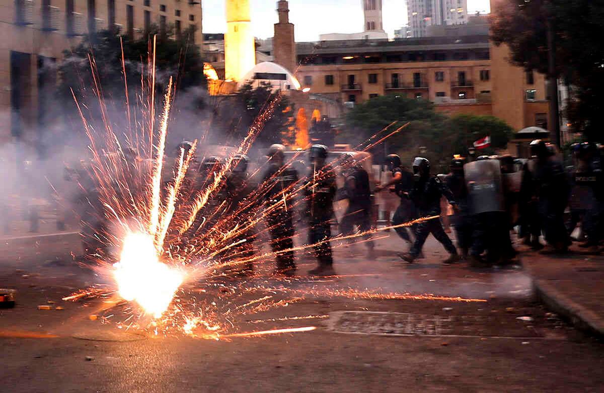 Manifestantes antigubernamentales utilizan fuegos artificiales contra la policía antidisturbios libanesa.  AP Photo/Bilal Hussein.