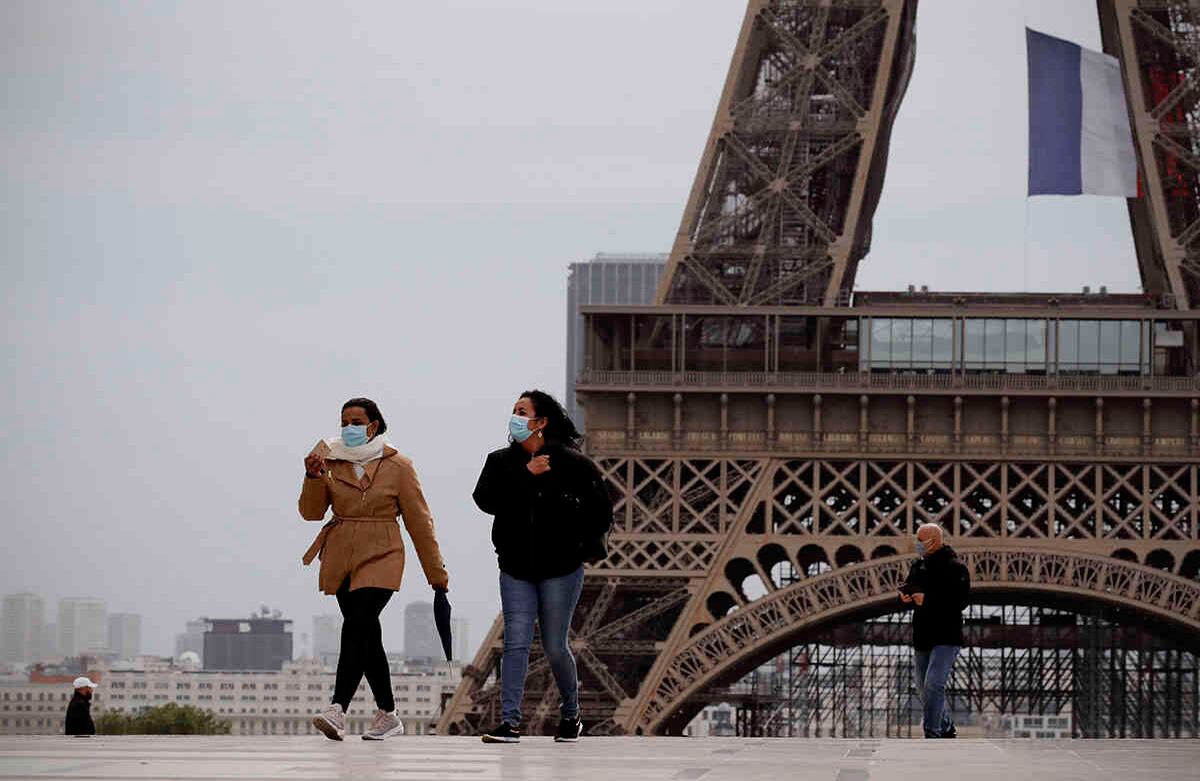 Gente camina cerca de la Torre Eiffel, en París, el lunes 11 de mayo de 2020. Los franceses dejan sus casas y apartamentos por primera vez en dos meses cuando el país levanta cautelosamente su cuarentena. Tiendas de ropa, peluquerías y otras empresas grandes y pequeñas reabrieron el lunes con estrictas precauciones para mantener el coronavirus a raya. Foto: Christophe Ena/AP