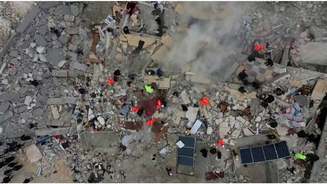 Los rescatistas buscan entre los escombros de los edificios derrumbados después de un terremoto, en la ciudad de Sarmada, Siria , controlada por los rebeldes.