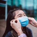 Mamá ayudando a su hija a usar mascarilla médica