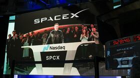 SpaceX CEO Elon Musk, displayed on a screen remotely from SpaceX headquarters in Starbase, Texas, speaks before the launch of SpaceX�s initial public offering (IPO) at the Nasdaq MarketSite in New York on June 12, 2026. Elon Musk's SpaceX begins trading on the Nasdaq exchange on Friday with the biggest initial public offering in history expected to make the polarizing entrepreneur the world's first trillionaire. The company priced more than 555 million shares at $135 each in a filing with the US markets regulator on Thursday, placing SpaceX in the top 10 of Wall Street's biggest companies with a valuation of just under $1.8 trillion -- ahead of Tesla, Facebook-owner Meta and Walmart. (Photo by TIMOTHY A. CLARY / AFP)