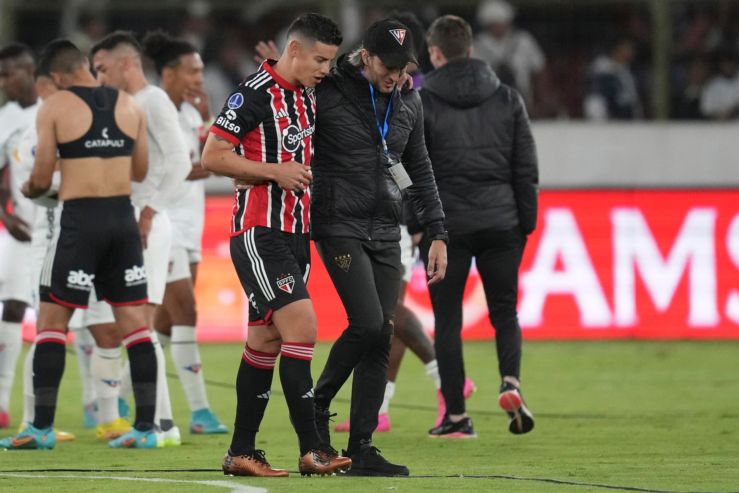 Coach Luis Zubeldia, right, of Ecuador's Liga Deportiva Universitaria walks off the pitch with James Rodriguez of Brazil's Sao Paulo after a Copa Sudamericana quarterfinal, first leg soccer match at Rodrigo Paz Delgado stadium in Quito, Ecuador, Thursday, Aug. 24, 2023. (AP Photo/Dolores Ochoa)