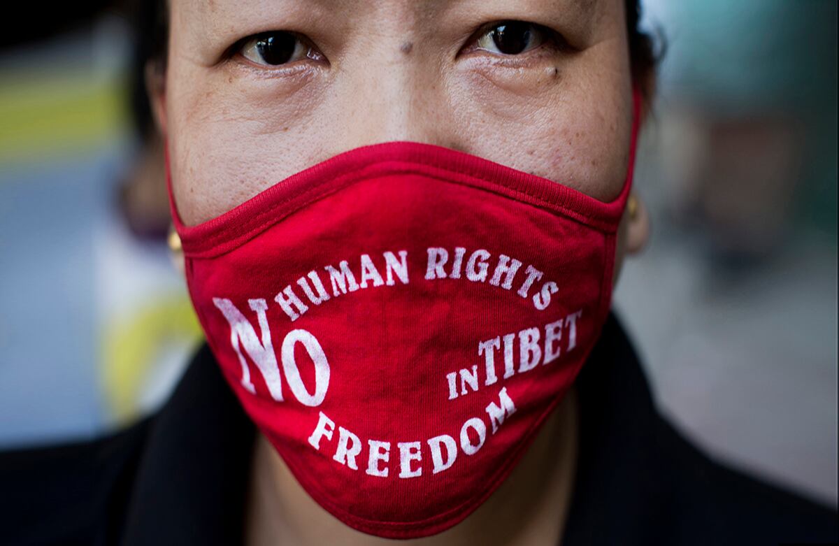 Durante una visita de Xi Jinping, presidente chino, a la India, una exiliada tibetana usa una máscara para protestar por el control de China sobre el Tíbet. (AP)