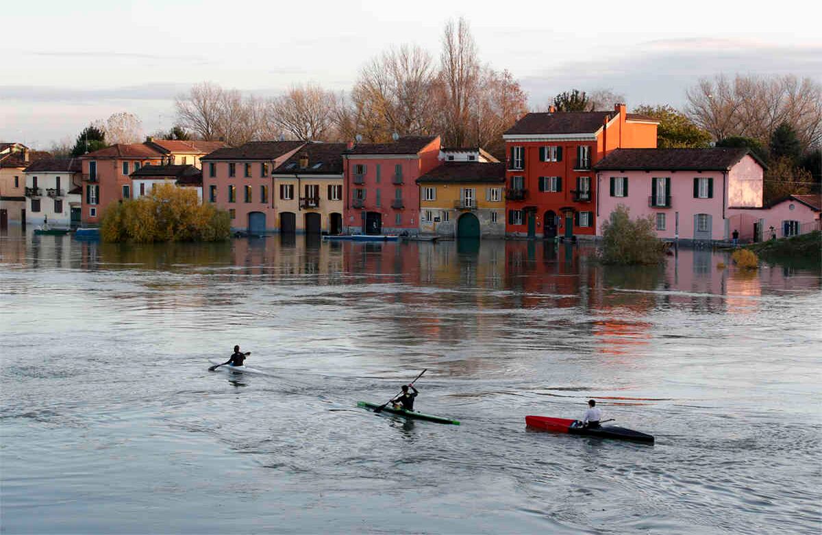 Piragüistas navegan mientras el agua inunda las casas después de que el río Ticino se desbordara, en Pavía, Italia, el lunes 25 de noviembre de 2019. Al menos siete personas murieron cuando las fuertes lluvias azotaron las costas de Francia e Italia, así como partes del oeste de Grecia. Algunas carreteras permanecieron cerradas el lunes en la Riviera francesa. (Foto: AP / Antonio Calanni)