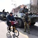 Un hombre pasa junto a una columna de vehículos blindados de transporte de personal húngaros mientras el ejército húngaro despliega tropas cerca de la frontera entre Hungría y Ucrania, en Vasarosnameny, Hungría, el viernes 25 de febrero de 2022. Hungría ha desplegado sus fuerzas armadas en territorios orientales cerca de Ucrania frontera para ayudar en los preparativos para la llegada de refugiados. (Foto AP/Anna Szilagyi)