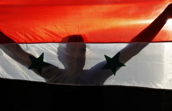 Un manifestante palestino sostiene una bandera siria durante una protesta contra la invasión estadounidense en el campo de refugiados de Rafah, en la Franja de Gaza. 