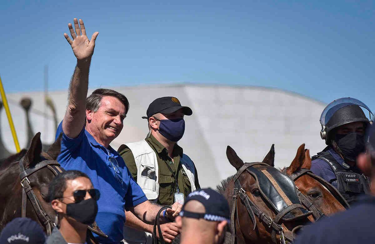 Jair Bolsonaro saluda a sus seguidores montado en un caballo de la policía, ante el palacio presidencial en Brasilia, Brasil, el domingo 31 de mayo de 2020. Foto: Andre Borges / AP.