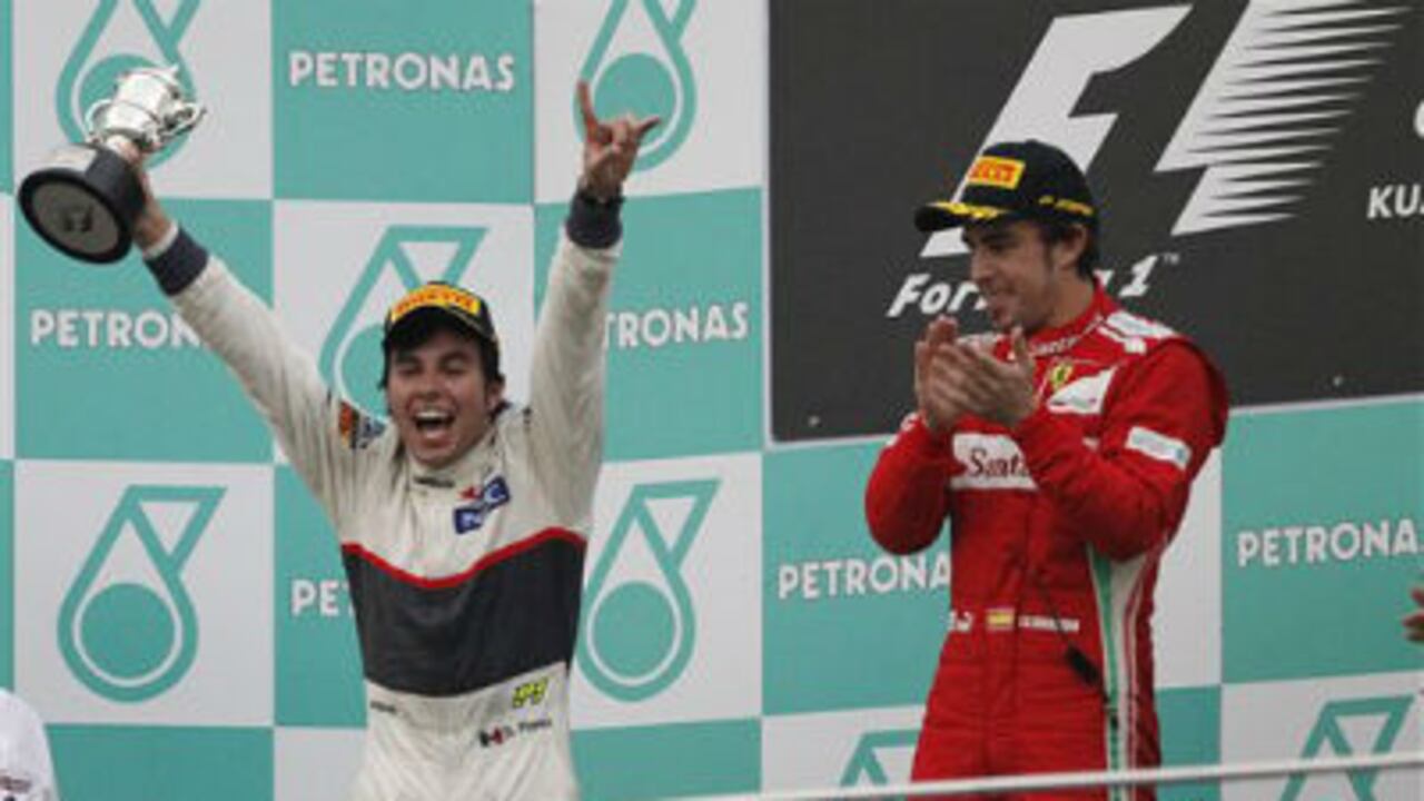 El mexicano Sergio Pérez (i), de la escudería Sauber, celebra su segundo lugar en el Gran Premio de Malasia de Förmula Uno. A su lado, el vencedor de la competencia, Fernando Alosnso (d).