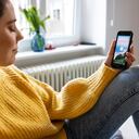 Woman relaxing by listening to mindfulness music from smartphone app. Caucasian woman wearing wireless earphones listening and feeling the music while at home.