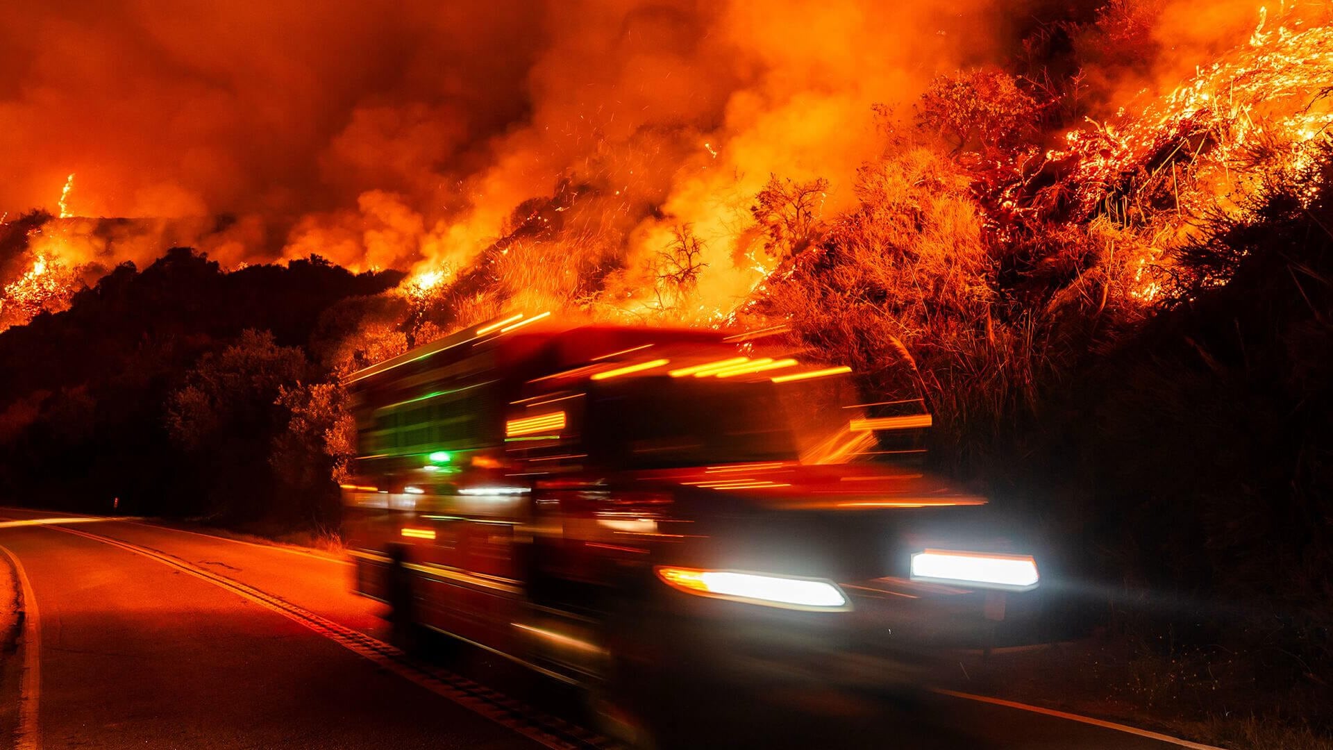 Un camión de bomberos pasa junto al incendio forestal Plaskett Fire, que avanza hacia la autopista 1, el viernes 28 de agosto de 2026, en Big Sur, California.