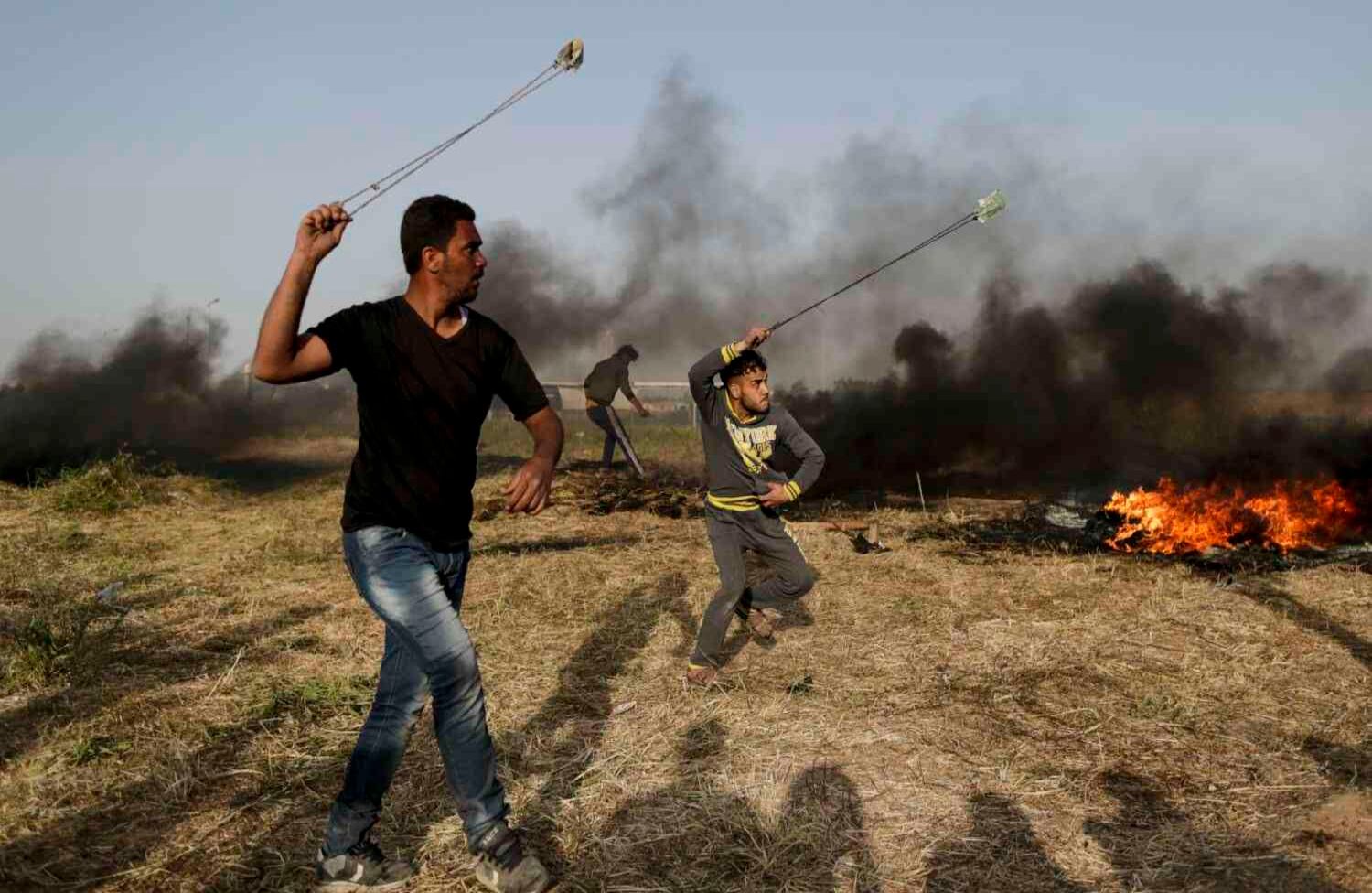 Gaza Sube la tensión  Protestantes palestinos usan bastones de fuego durante su enfrentamiento con fuerzas israelíes. Las manifestaciones de la última semana dejan a 21 personas muertas y más de 350 heridos. AFP/ Mahmud Hams 