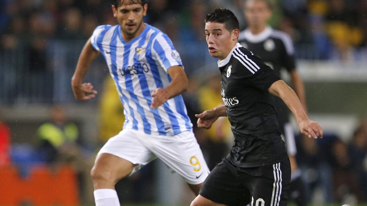 El colombiano James Rodríguez juega un balón ante el paraguayo Roque Santa Cruz, del Málaga.