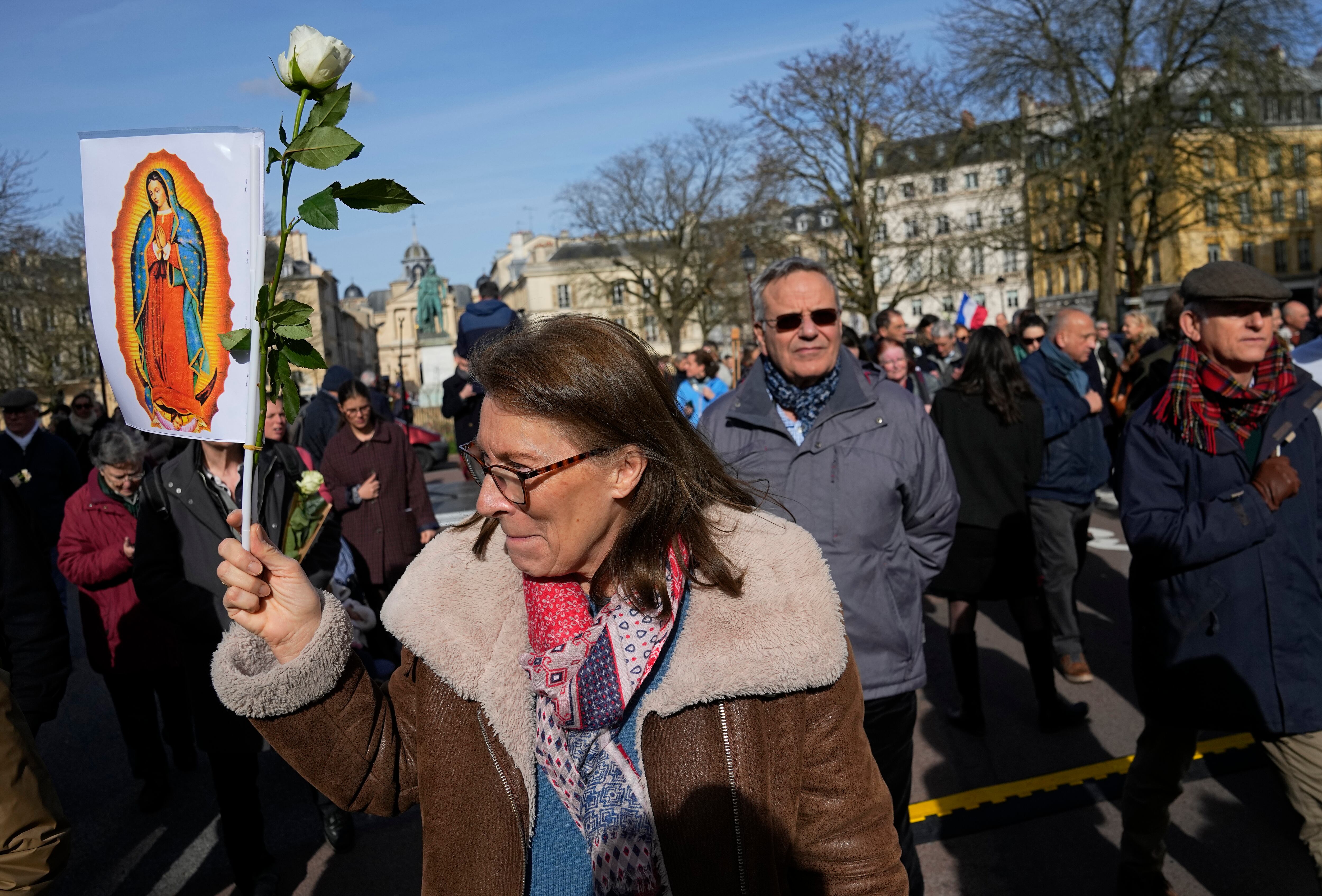 Un activista antiaborto sostiene un cartel que representa a la Virgen María cerca del Palacio de Versalles durante la sesión del Congreso de ambas Cámaras del Parlamento en Versalles, al oeste de París, el lunes 4 de marzo de 2024.