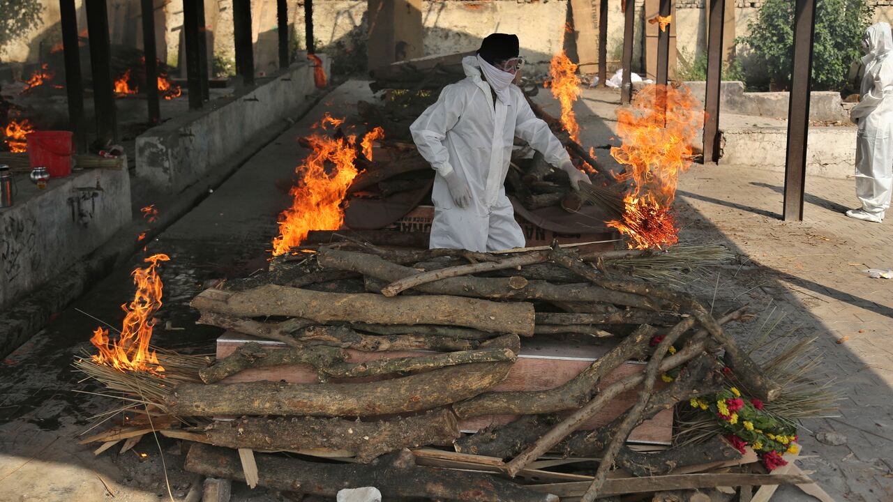 Un familiar de una persona fallecida por el coronavirus, a quien están incinerando, en Jammu, India. (AP Foto/Channi Anand)