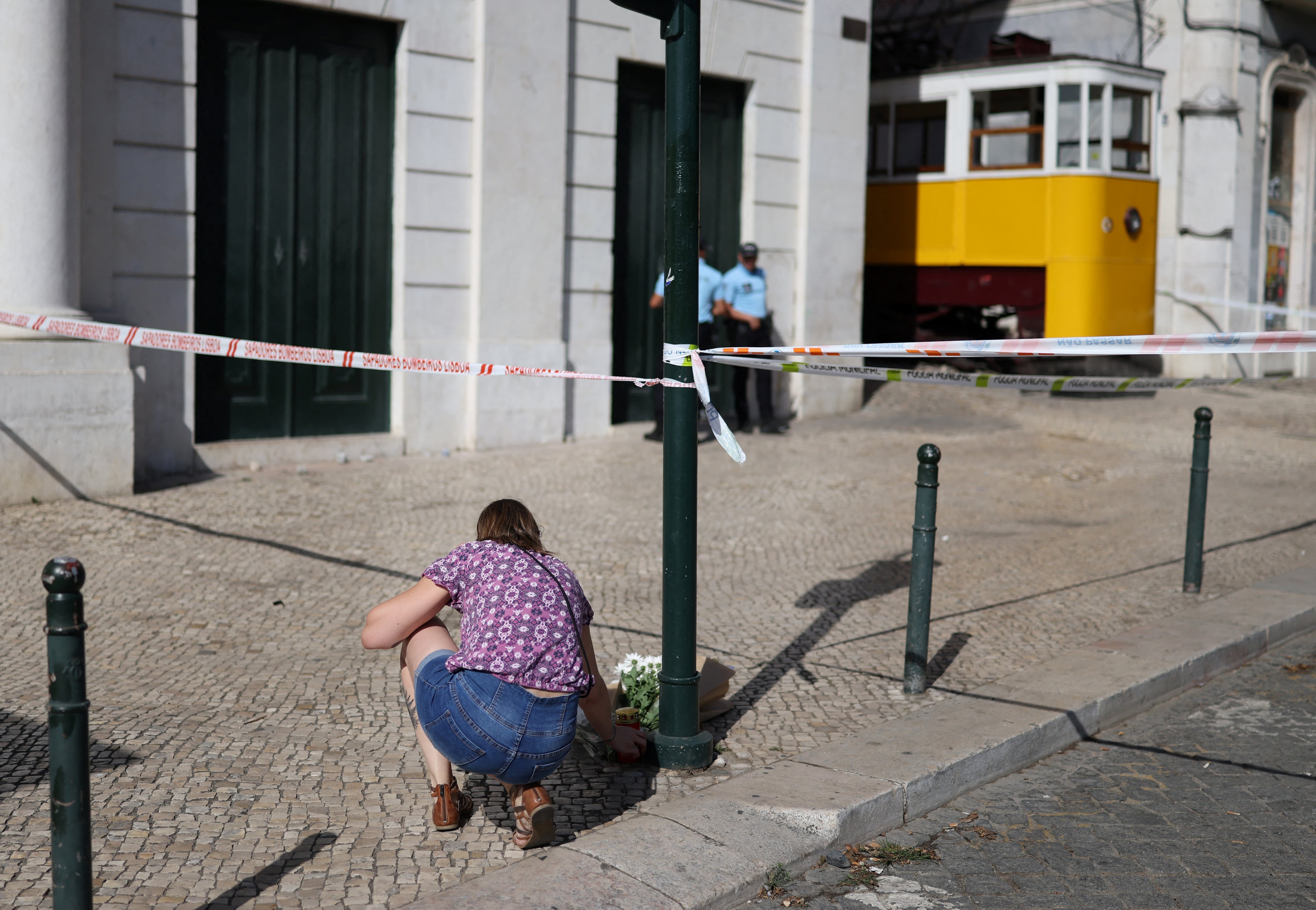 Una mujer deposita flores en homenaje a las víctimas en el lugar del Funicular Gloria el día después del accidente que dejó 16 muertos en Lisboa, el 4 de septiembre de 2025