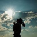 Mujer lanza una plegaria al cielo.