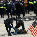 (FILES) In this file photo taken on January 6, 2021, police detain a person as supporters of US President Donald Trump riot outside the US Capitol in Washington, DC. - A day after the Senate acquitted Donald Trump in a historic second impeachment trial, America was weighing how long a shadow the former president, even with a tarnished legacy, will continue to cast -- over his party, and over the country. As much of the world watched, the Senate on February 13, 2021 voted 57-43 to convict Trump of inciting the January 6 assault on the US Capitol. It was a stinging rebuke, with seven Republicans joining all Democrats in the most bipartisan impeachment vote ever, but it fell short of the 67 votes needed for conviction. (Photo by ROBERTO SCHMIDT / AFP)