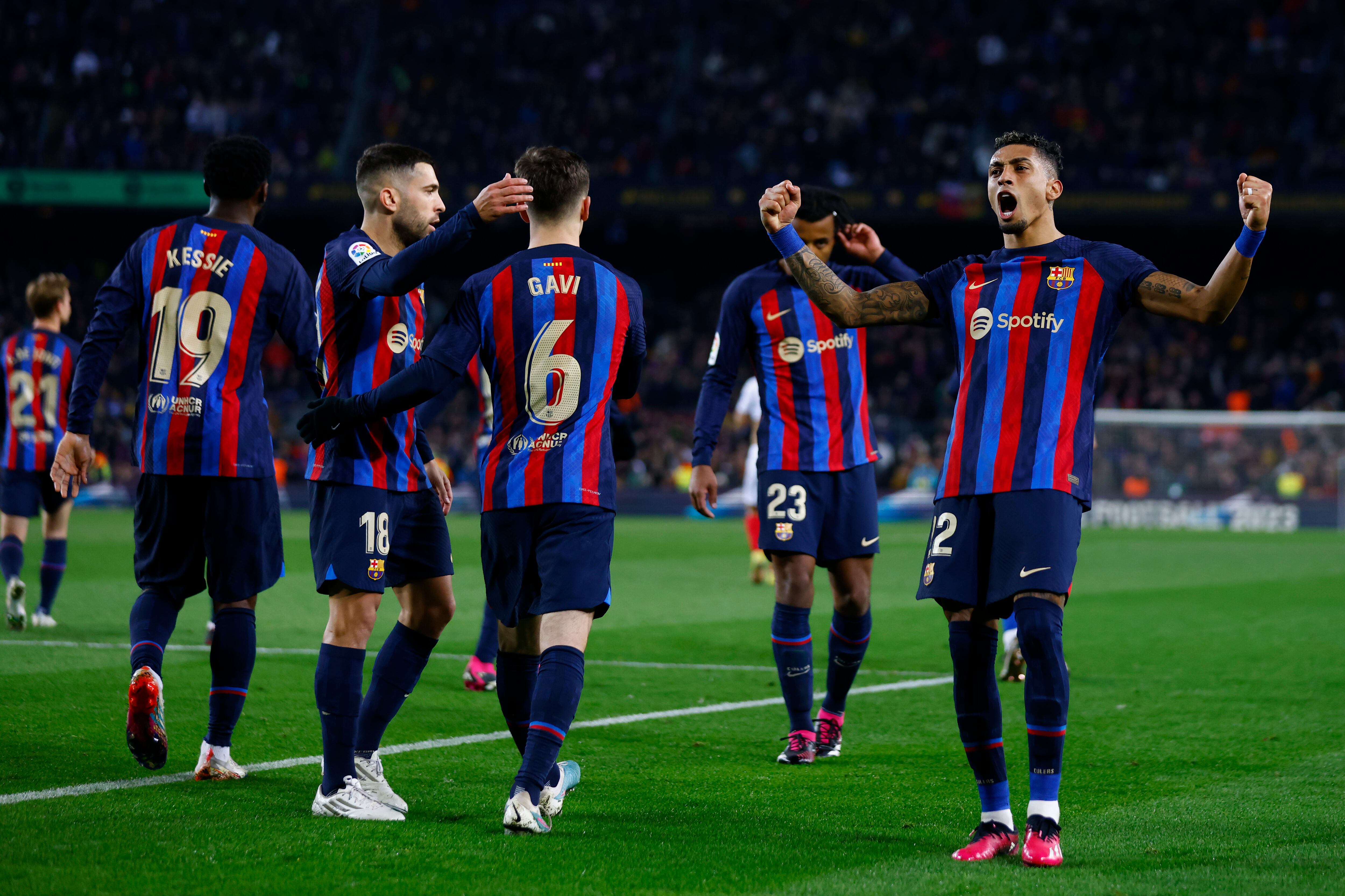 Barcelona's Raphinha, right, celebrates after scoring his side's third goal during a Spanish La Liga soccer match between Barcelona and Sevilla at the Camp Nou stadium in Barcelona, Spain, Sunday, Feb. 5, 2023. (AP Photo/Joan Monfort)