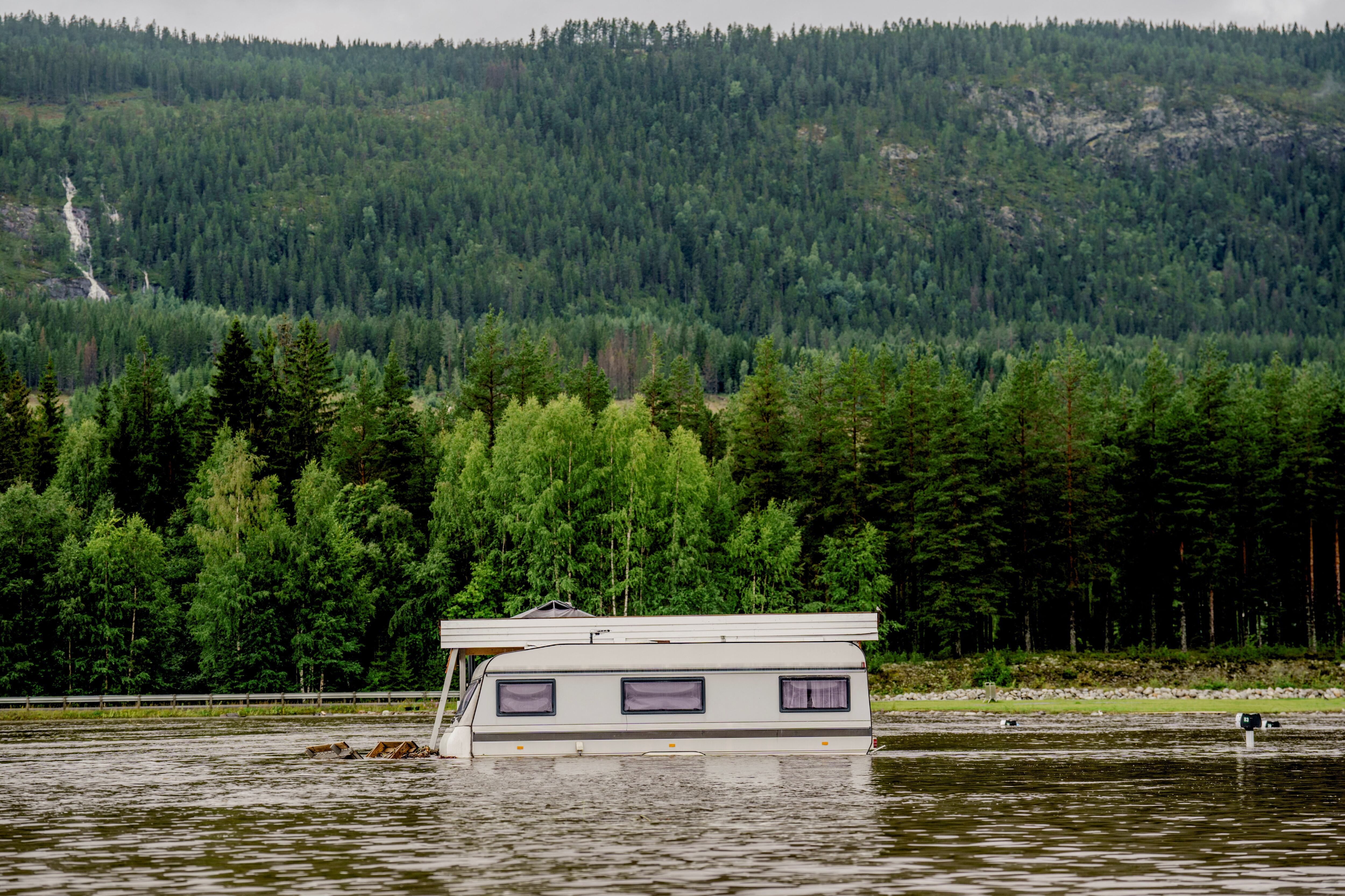 Esta foto tomada el 9 de agosto de 2023 muestra una caravana parcialmente rodeada de agua, después de que un campamento en Dokka se inundara por completo después de que el río Dokka se desbordara. Las fuertes lluvias causaron inundaciones y deslizamientos de tierra en Suecia y Noruega el 8 de agosto, mientras que los fuertes vientos provocaron que un incendio forestal danés se extendiera fuera de control, dijeron las autoridades, y se pronostican más lluvias intensas.