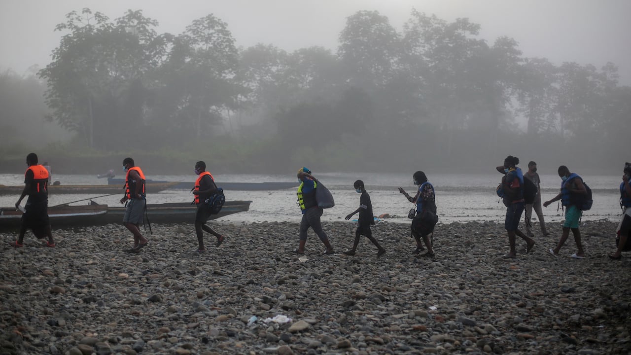 Los migrantes caminan hacia la embarcación donde serán transportados desde el poblado de Bajo Chiquito hasta la Estación de Recepción de Migrantes en Lajas Blancas, Provincia de Darién, en Panamá el 23 de agosto de 2021. - Migrantes de Haití y otros países arriban a territorio panameño, luego de caminar cinco días en el Darien Gap. Panamá y Colombia llegaron a un acuerdo para controlar la avalancha de migrantes que cruzan la frontera común hacia Estados Unidos. (Foto de ROGELIO FIGUEROA / AFP)