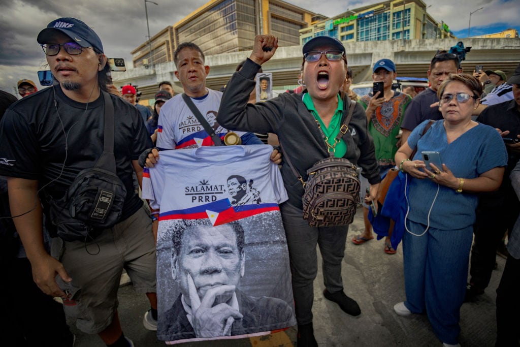 MANILA, PHILIPPINES - MARCH 11: Supporters of former President Rodrigo Duterte gather outside Villamor Airbase, where Duterte was taken following his arrest on an International Criminal Court (ICC) warrant, on March 11, 2025 in Pasay, Metro Manila, Philippines. Former Philippine President Rodrigo Duterte has been arrested on an International Criminal Court (ICC) warrant for crimes against humanity linked to thousands of deaths over his brutal anti-drug campaign. His arrest follows an extensive international investigation into these killings. (Photo by Ezra Acayan/Getty Images)