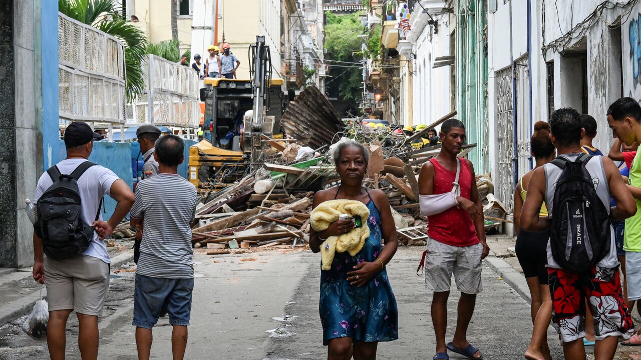 Vecinos observan mientras los rescatistas trabajan en un bloque de apartamentos tras un derrumbe, en La Habana, el 4 de octubre de 2023. (Foto: Yamil LAGE / AFP)