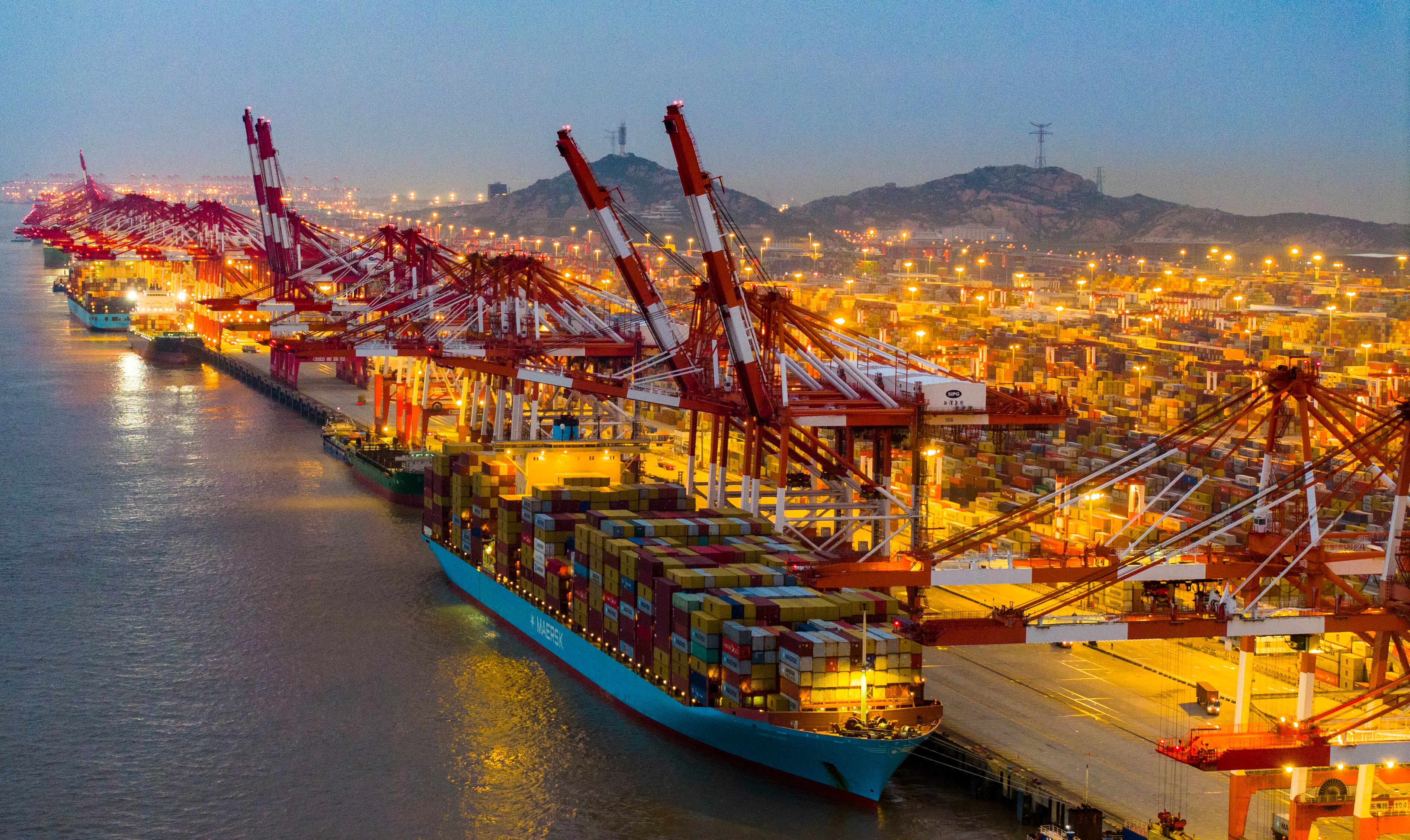 Vista aérea de grandes buques portacontenedores y contenedores de envío en el iluminado puerto de aguas profundas de Yangshan el 18 de octubre de 2024 en Shanghai, China. (Foto de Ji Haixin/VCG vía Getty Images)