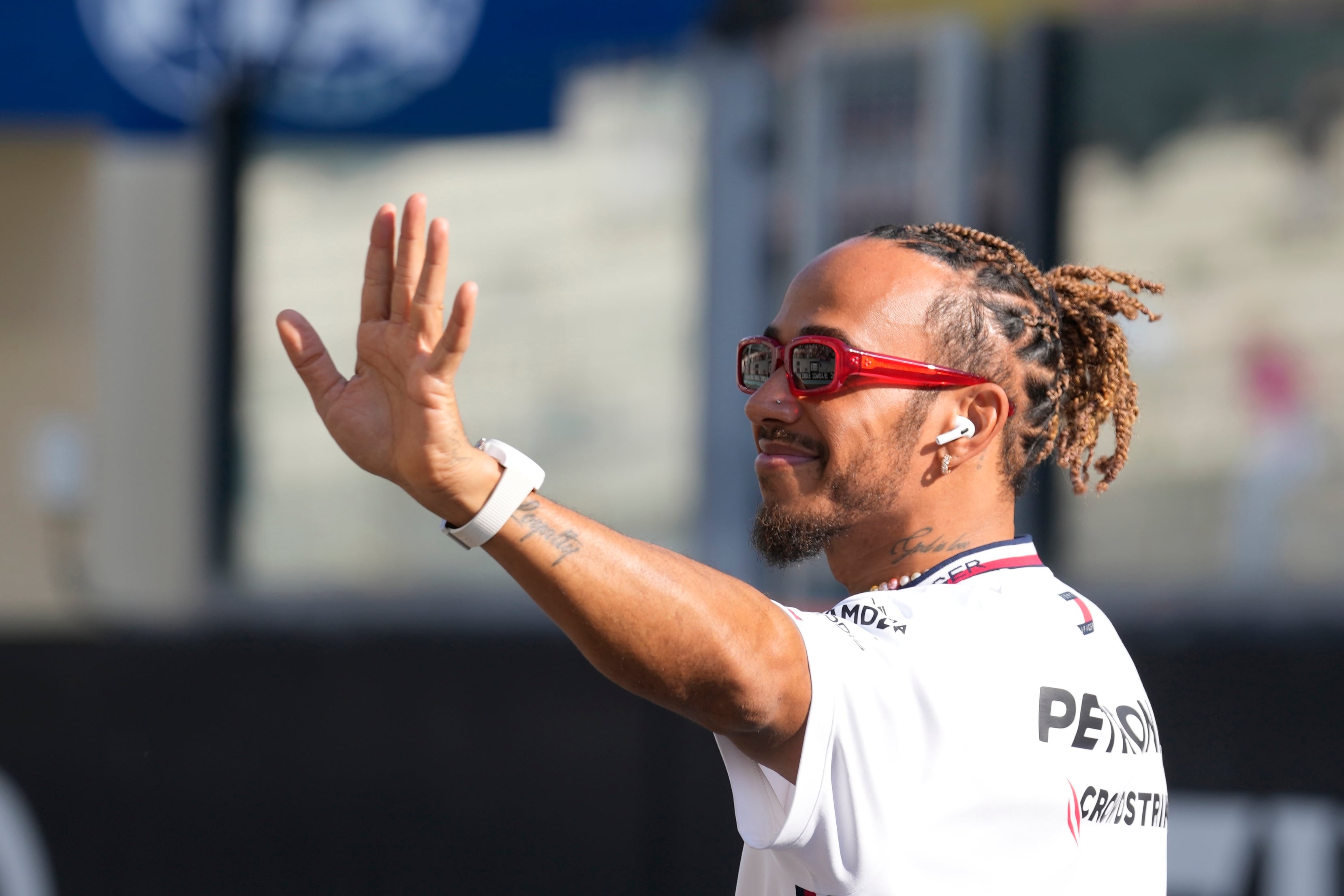 FILE - Mercedes driver Lewis Hamilton of Britain, waves as he arrives for the F1 drivers group picture ahead the drivers parade prior to the Abu Dhabi Formula One Grand Prix at the Yas Marina racetrack in Abu Dhabi, United Arab Emirates, Sunday, Nov. 26, 2023. Seven-time Formula One champion Lewis Hamilton has been linked with a shock move from Mercedes to Ferrari next year. (AP Photo/Kamran Jebreili, File)