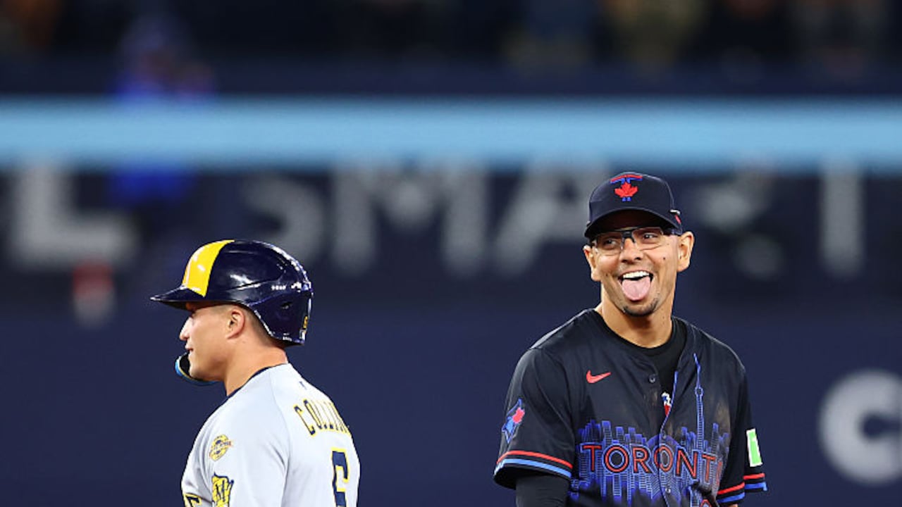 TORONTO, ON - AUGUST 29: Andrés Giménez #0 of the Toronto Blue Jays laughs with Isaac Collins #6 of the Milwaukee Brewers after Collins steals second base in the eighth inning during a game at Rogers Centre on August 29, 2025 in Toronto, Ontario, Canada. (Photo by Vaughn Ridley/Getty Images)