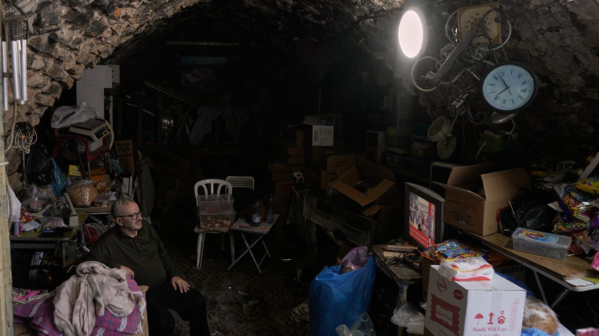 Un vendedor ambulante ve las noticias en la televisión después del anuncio de que Israel y Hamas han acordado la primera fase de un plan de paz para detener los combates, mientras se sienta en su tienda en la Ciudad Vieja de Nablus, en Cisjordania. Jueves 9 de octubre de 2025.