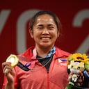 Hidilyn Díaz, medallista de oro de Filipinas, subió al podio para la ceremonia de la victoria de la competencia femenina de halterofilia de 55 kg durante los Juegos Olímpicos de Tokio 2020 en el Foro Internacional de Tokio en Tokio el 26 de julio de 2021 (Foto de Vincenzo PINTO / AFP).