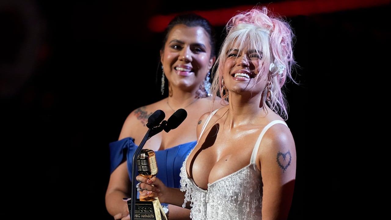Karol G, right, accepts the Spirit of Hope Award at the Latin Billboard Awards, Thursday, Oct. 5, 2023, in Coral Gables, Fla. (AP Photo/Marta Lavandier)