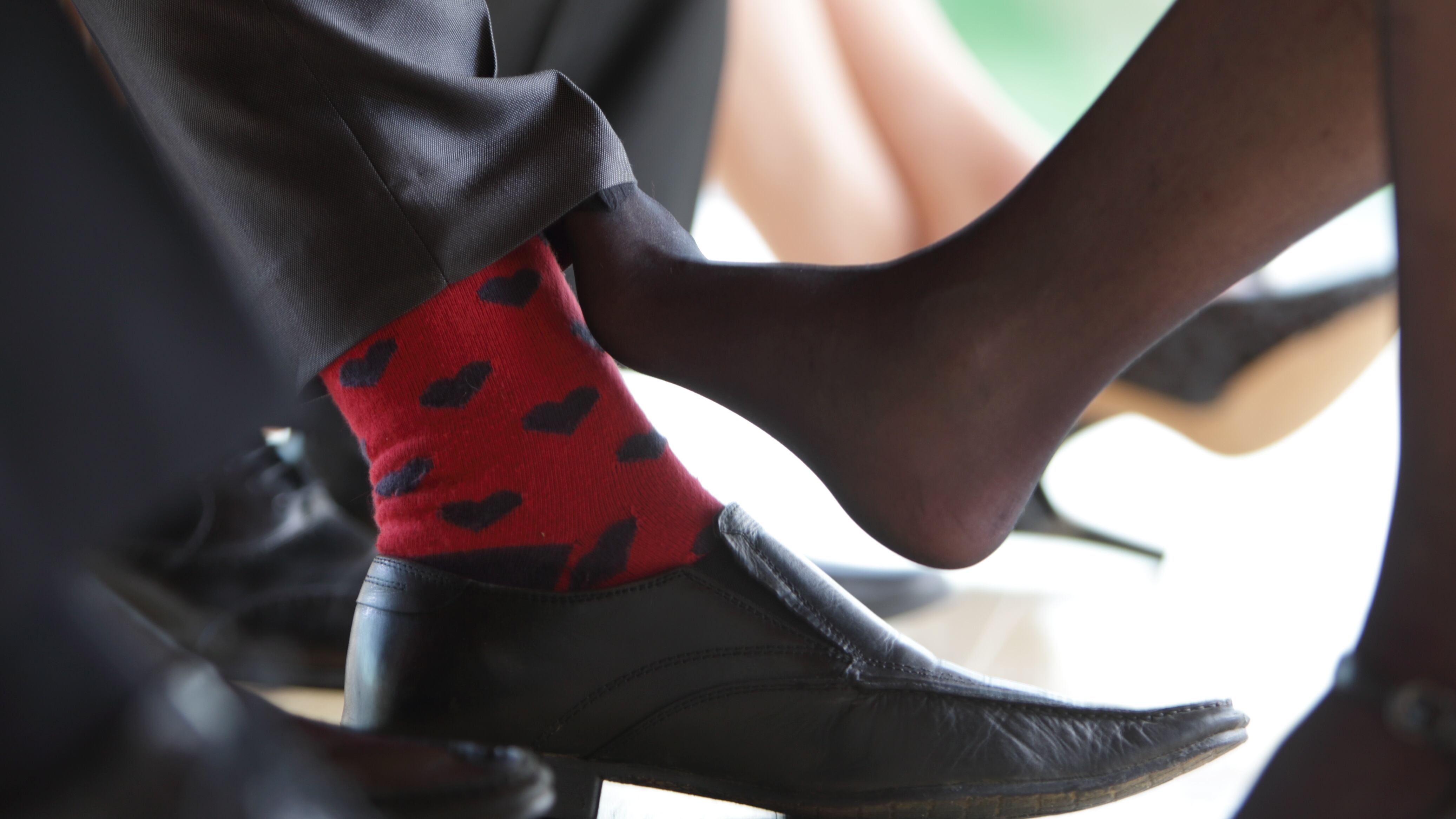 ambiente de oficina, jugando con los pies. Mujer juega con sus pies por debajo de la mesa, juego de amantes, infidelidad, infieles. Mujer rosa su pie con el pie de un hombre, coqueteo.