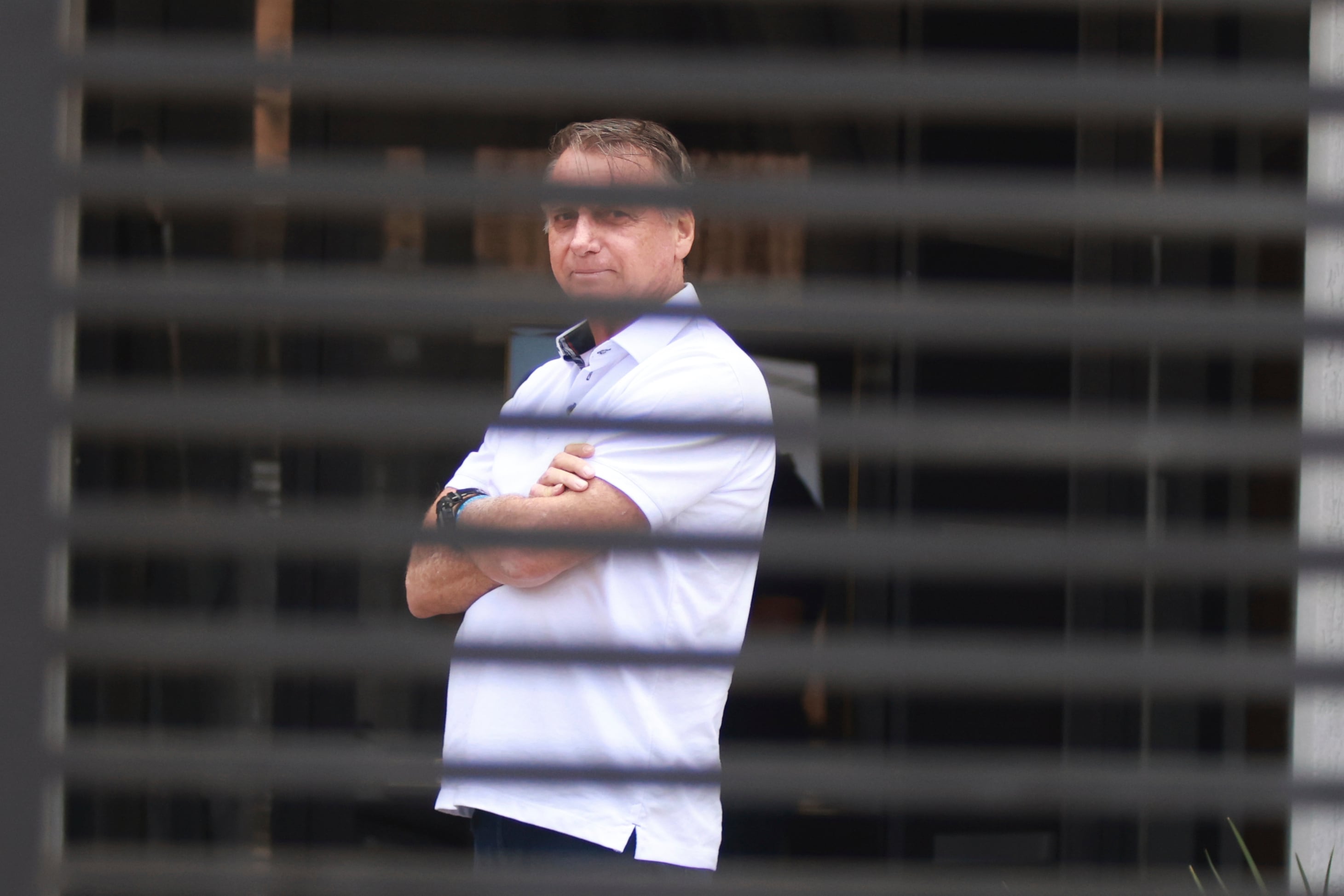 El expresidente brasileño Jair Bolsonaro en la entrada de su casa mientras cumple su condena de arresto domiciliario en Brasilia, Brasil.
