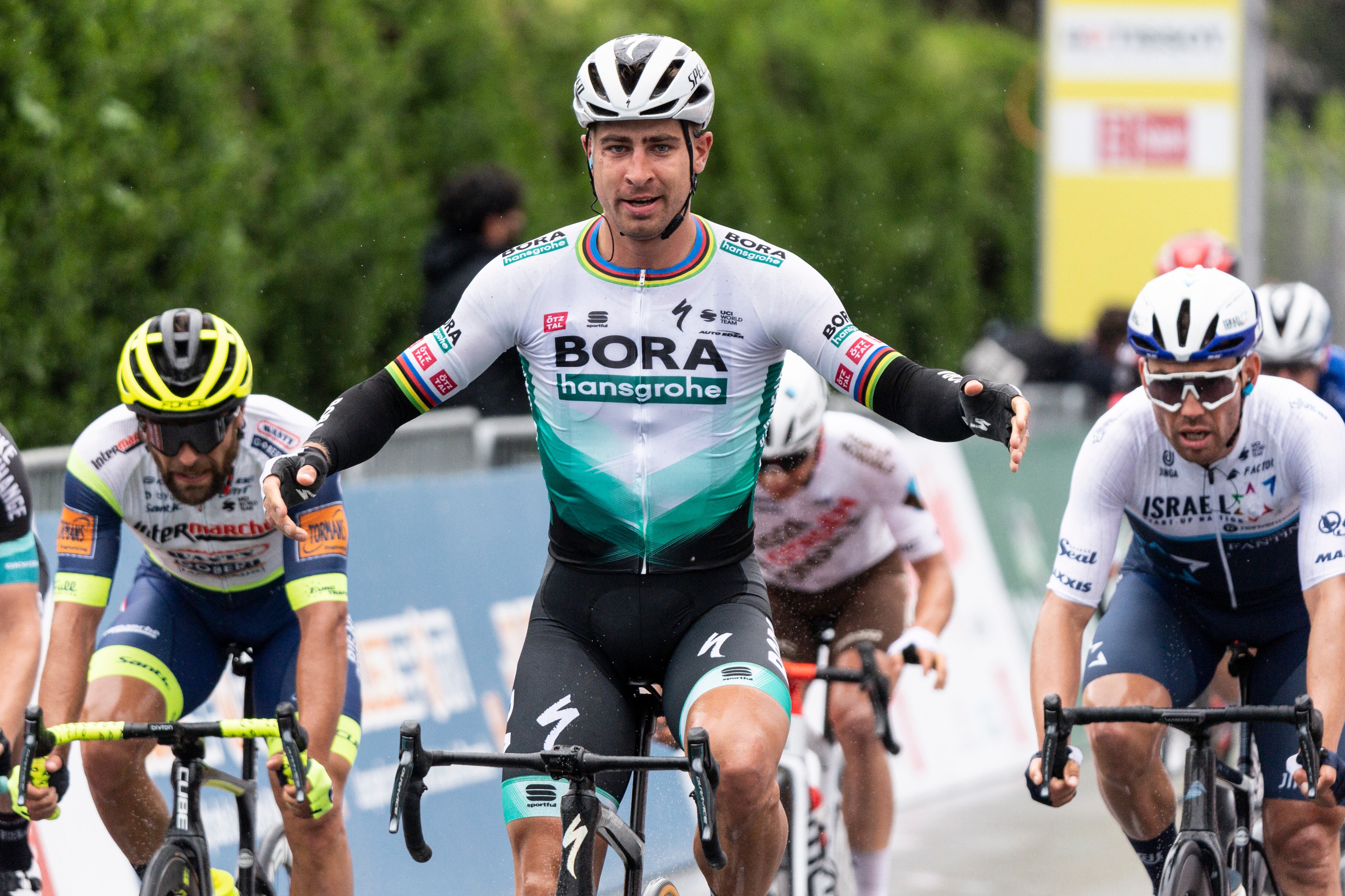 Peter Sagan de Eslovaquia del equipo Bora-Hansgrohe, en el centro, cruza la línea de meta como el ganador de la primera etapa, una carrera de 168 km entre Aigle y Martigny en la 74a carrera ciclista Tour de Romandie UCI ProTour en Martigny, Suiza, el miércoles de abril. 28, 2021. (Jean-Christophe Bott / Keystone vía AP)