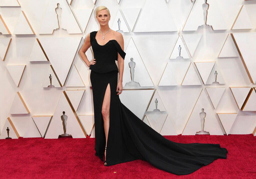 La modelo y actriz sudafricana Charlize Theron desfiló por la alfombra roja en un largo vestido negro, con escote oval, firmado por Christian Dior. Foto: Richard Shotwell / AP.