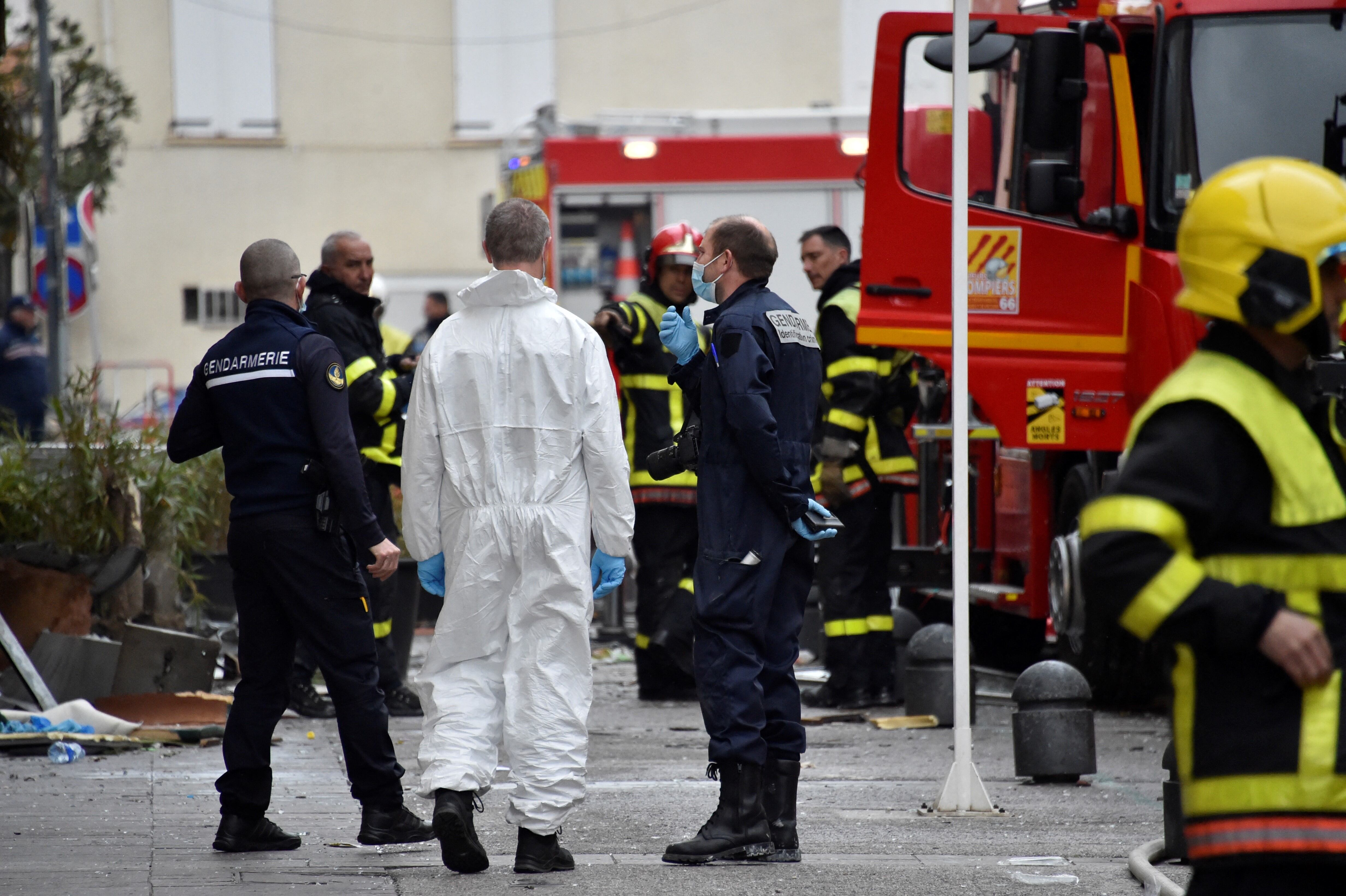 Gendarmes y bomberos trabajan en el lugar de un incendio que se desató en un edificio de viviendas, matando a siete de sus residentes en Saint-Laurent-de-la-Salanque, el 14 de febrero de 2022. (Foto de RAYMOND ROIG / AFP)