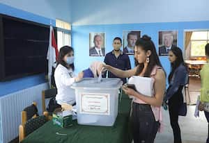 Una mujer siria deposita su voto en un colegio electoral de Damasco el 26 de mayo de 2021, cuando comenzó la votación en toda Siria para unas elecciones que garantizan el regreso del presidente Bashar al-Assad para un cuarto mandato/AFP/LOUAI BESHARA