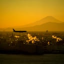 Un avión se prepara para aterrizar en el Aeropuerto Internacional Haneda de Tokio el martes 10 de enero de 2023 en Tokio mientras el Monte Fuji se ilumina con el cielo del atardecer en el fondo.