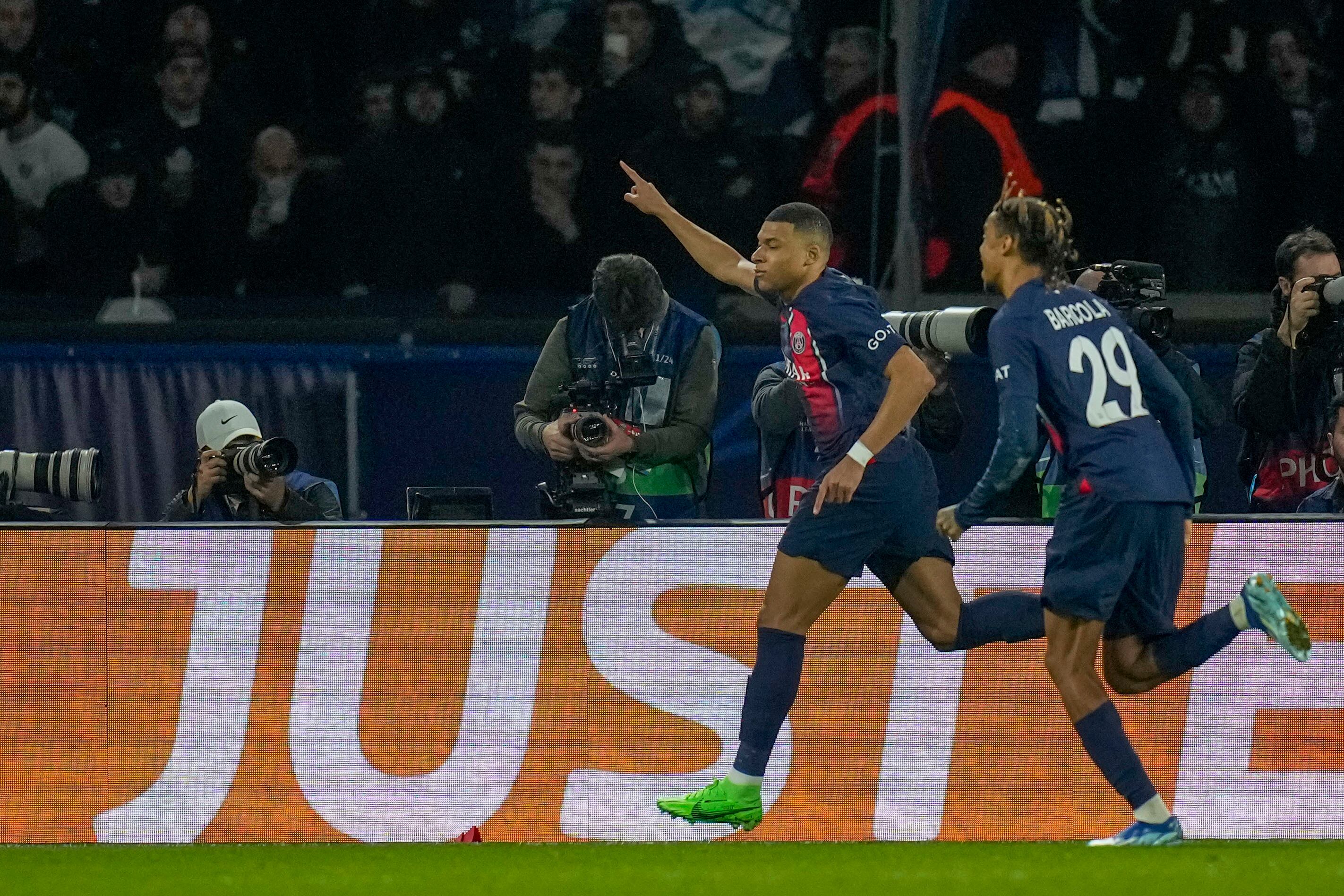 PSG's Kylian Mbappe, left, celebrates with PSG's Bradley Barcola after scoring his side's opening goal during the Champions League round of 16 first leg soccer match between Paris Saint-Germain and Real Sociedad, at the Parc des Princes stadium in Paris, France, Wednesday, Feb. 14, 2024. (AP Photo/Christophe Ena)