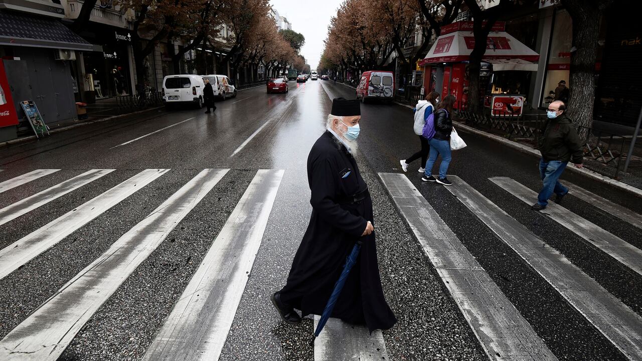 Un sacerdote ortodoxo griego que usa una máscara facial para protegerse contra la propagación del coronavirus, camina durante el cierre para contener la propagación del COVID-19, en la calle Tsimiski, la principal zona comercial de Tesalónica, en el norte de Grecia, el martes 3 de noviembre de 2020. Foto: AP / Giannis Papanikos.