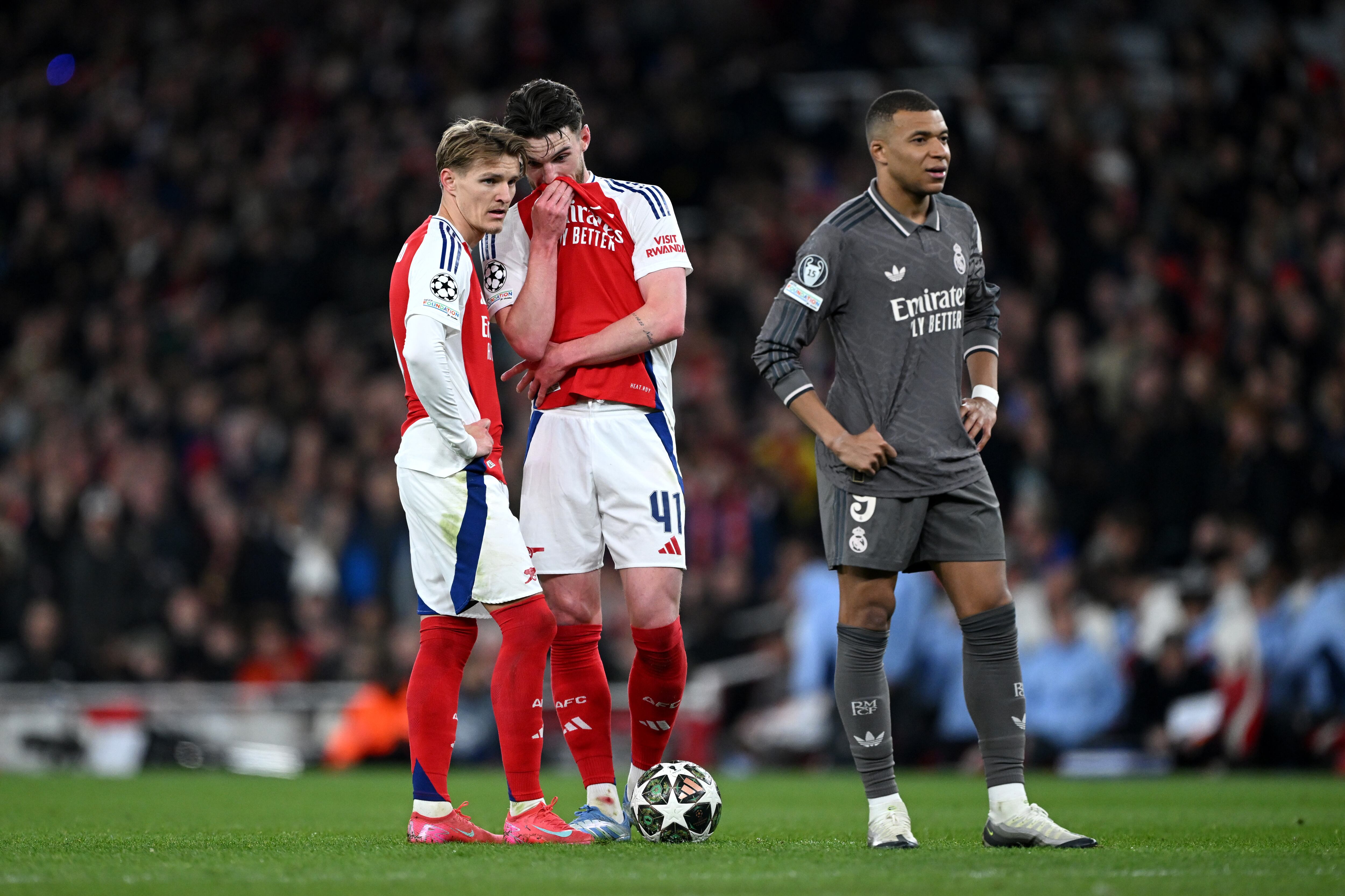 LONDON, ENGLAND - APRIL 08: Declan Rice of Arsenal speaks to team mate Martin Odegaard as Kylian Mbappe of Real Madrid looks on during the UEFA Champions League 2024/25 Quarter Final First Leg match between Arsenal FC and Real Madrid C.F. at Emirates Stadium on April 08, 2025 in London, England. (Photo by Shaun Botterill/Getty Images)