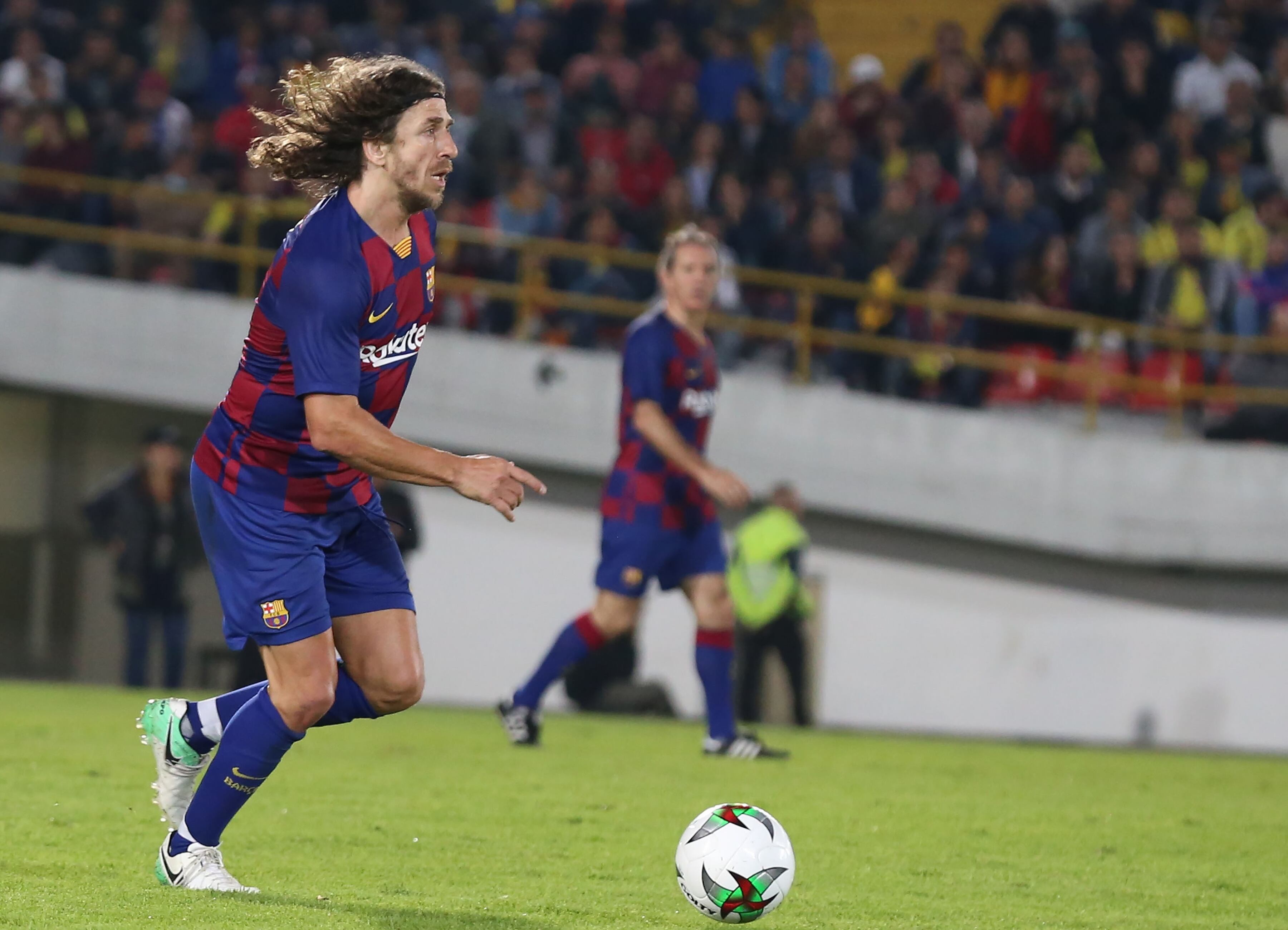 BOGOTA, COLOMBIA - MARCH 5: Former Spanish soccer player from Barca Legends Carles Puyol controls the ball against Colombia Legends during a friendly match at El Campin stadium in Bogota, Colombia, 5 March 2020. Spanish team of former soccer players Barca Legends was lead by Albert Ferrer, with such players as Juliano Belletti, Carles Puyol, Hristo Stoichkov and Javier Saviola. Colombian legends, coached by Francisco Maturana, include El Pibe Valderrama, Ivan Ramiro Cordoba, Freddy Rincon, Victor Hugo Aristizabal and Farid Mondragon. (Photo by Juan David Moreno Gallego/Anadolu Agency via Getty Images)