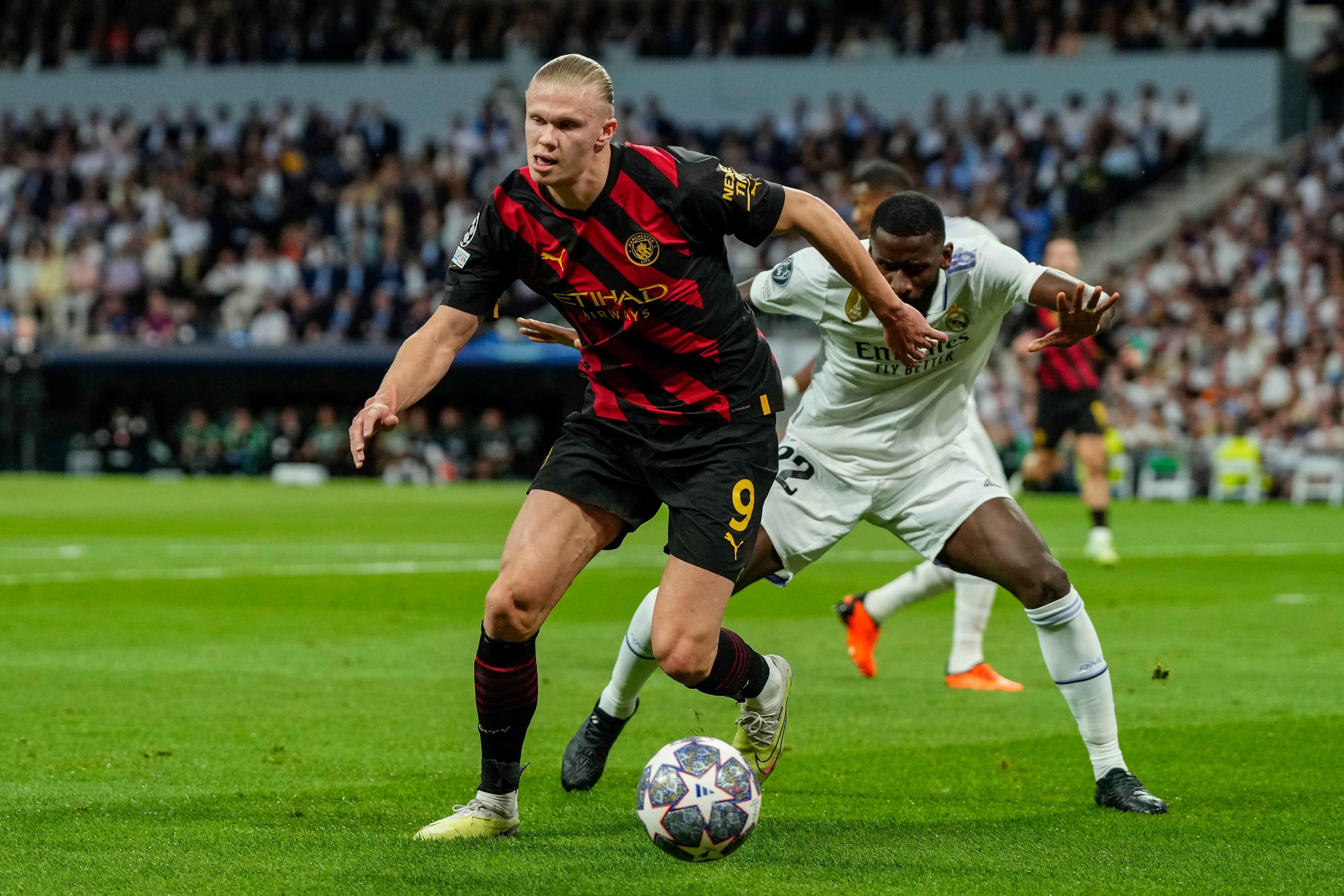 Manchester City's Erling Haaland, left, duels for the ball with Real Madrid's Antonio Rudiger during the Champions League semifinal first leg soccer match between Real Madrid and Manchester City at the Santiago Bernabeu stadium in Madrid, Spain, Tuesday, May 9, 2023. (AP/Jose Breton)