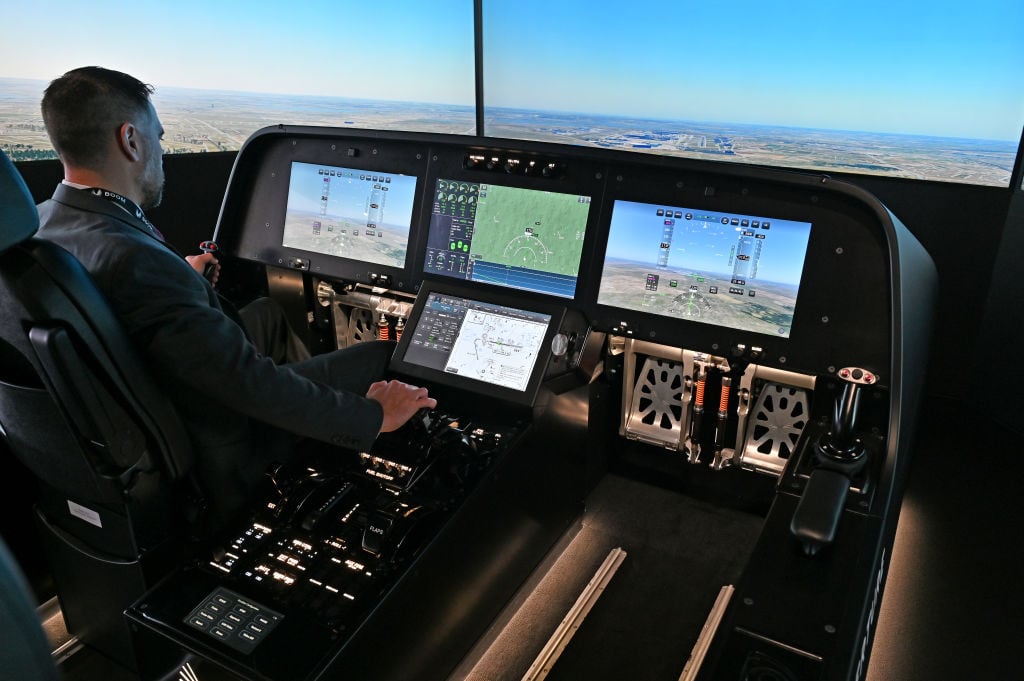 Un invitado prueba un simulador de vuelo para el Overture Supersonic Airliner en la sala de exposiciones Boom Supersonic durante el Salón Aeronáutico Internacional de Farnborough 2024 en el Centro Internacional de Conferencias y Exposiciones de Farnborough el 23 de julio de 2024 en Farnborough, Inglaterra. Boom Supersonic Overture será el avión de pasajeros más rápido del mundo, optimizado para velocidad, seguridad y sostenibilidad mediante el uso de combustibles de aviación (SAF) 100% sostenibles. La cartera de pedidos de Boom asciende a 130 aviones, incluidos pedidos y pedidos anticipados de American Airlines, United Airlines y Japan Airlines. Farnborough International Airshow 2024 acoge a los principales innovadores de las industrias aeroespacial, de aviación y de defensa. (Foto de John Keeble/Getty Images)