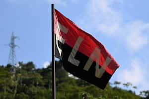 A flag of the National Liberation Army (ELN) guerrilla group flutters in the wind in Teorama municipality, Catatumbo region, Norte de Santander department, Colombia, on January 23, 2025. Colombia is battling its worst security crisis in a decade after a series of guerrilla attacks in the north of the country have left at least 80 people dead and displaced 36,000 others. (Photo by Raul ARBOLEDA / AFP)